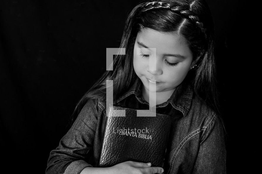  A young girl holding a Bible close to her heart 