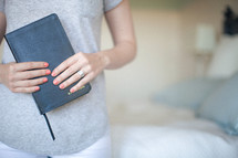 Woman holding a clsoed Bible.
