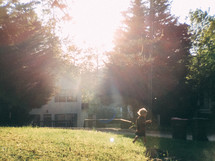 sunlight shining on a boy playing in his backyard 