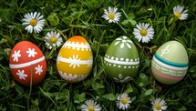 Colorful Easter eggs nestled in spring daisies on green grass. Festive holiday decoration and celebration concept