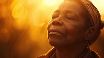 Portrait of a beautiful African woman with closed eyes in the sunlight, praying.