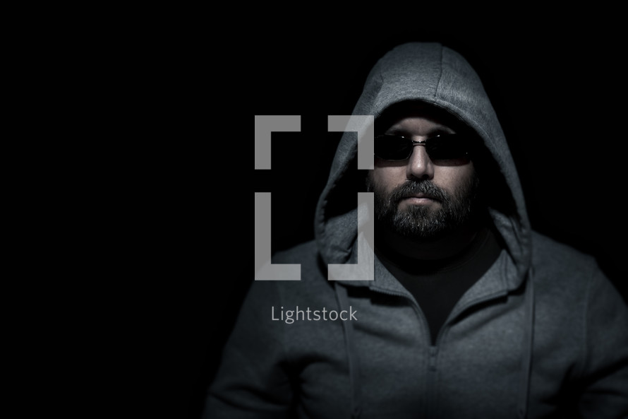 man in a hoodie and shades in darkness 