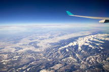 wing of a plan in flight over the Alps 