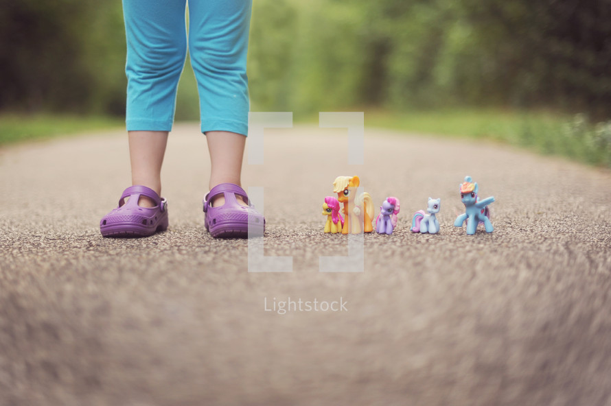 a child's feet and My Little Ponies 