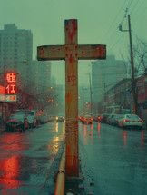 Old rusty cross on a street in the foggy morning.
