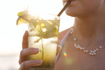 Woman enjoying a tropical mojito cocktail