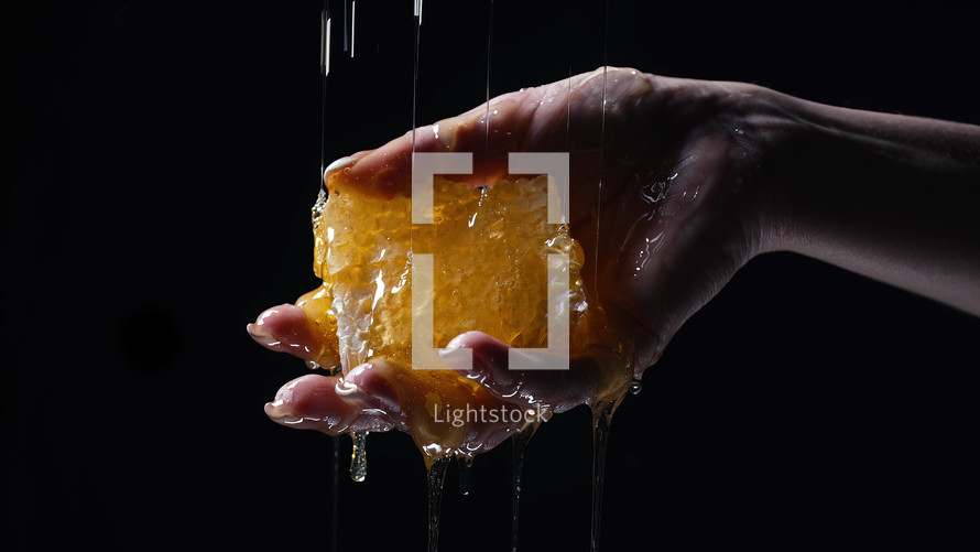 Woman hand with honeycombs full of honey. Dripping, pouring tasty sweet fluid. Thick golden flowing nectar. High quality photo