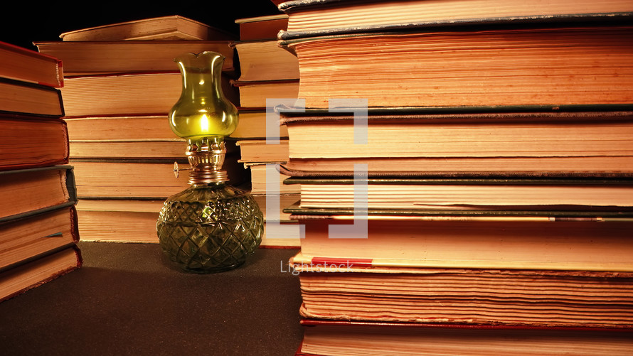 Gas lamp near stack of old books, slider footage in antique shop, bookstore. High quality photo