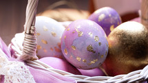 Beautiful Easter - colorful violet and golden eggs in woven basket. Craft holiday food decoration. Tasty religion symbol of spring, festive time. High quality