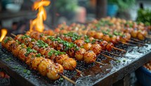 Takoyaki is a japanese food that is grilled on the stove.