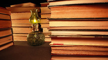 Gas lamp near stack of old books, slider footage in antique shop, bookstore. High quality photo