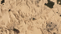 Aerial View of the Textures and Patterns of the Desert Sands. Beautiful landscape . Desert and green bushes.