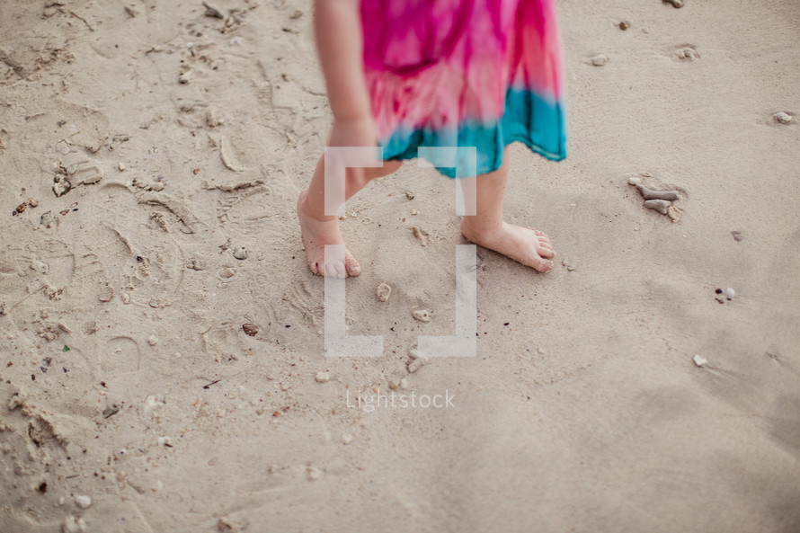 toddler girl walking in sand 