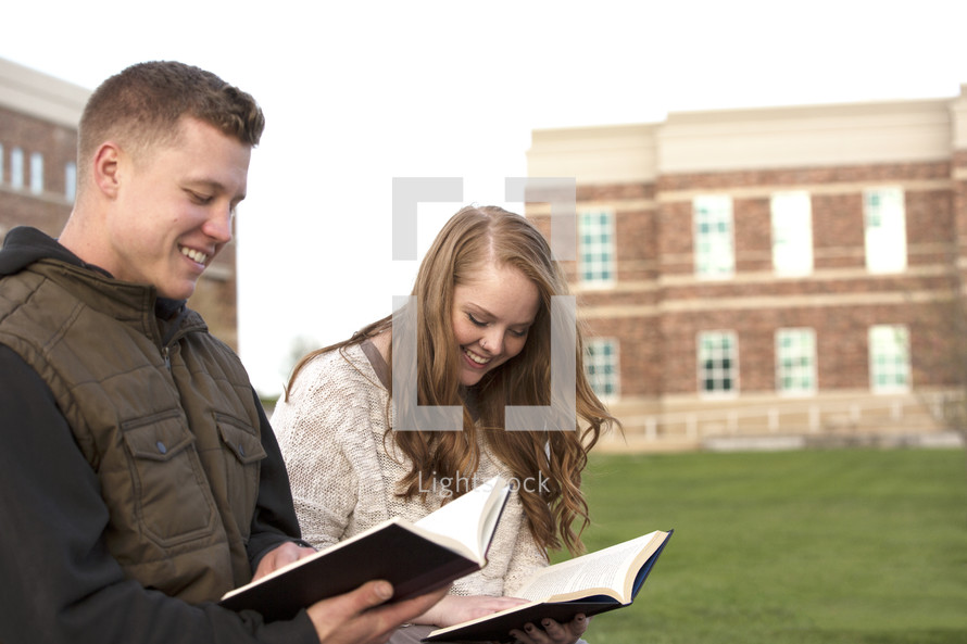 students reading books on campus 