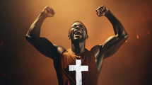 Portrait of a black man with a cross on his tank top celebrating victory, brown background