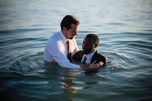 Baptism. A white Pastor baptize a black man in the water