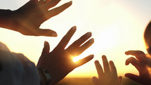 Mother and child silhouette with hands in sunlight