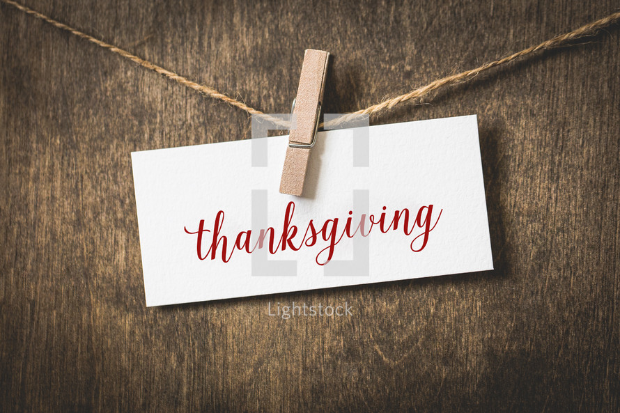 word Thanksgiving on white card stock hanging from a clothespin on a clothesline 
