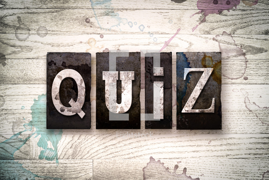word quiz on a white wash wood background 