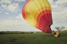 Hot air ballon taking off in a field 