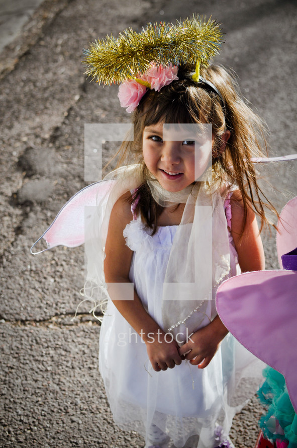 a girl child dressed as an angel in a live nativity scene 