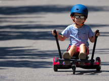boy on hoverboard or gyroscooter with kart accessory kit outdoor. New modern technologies
