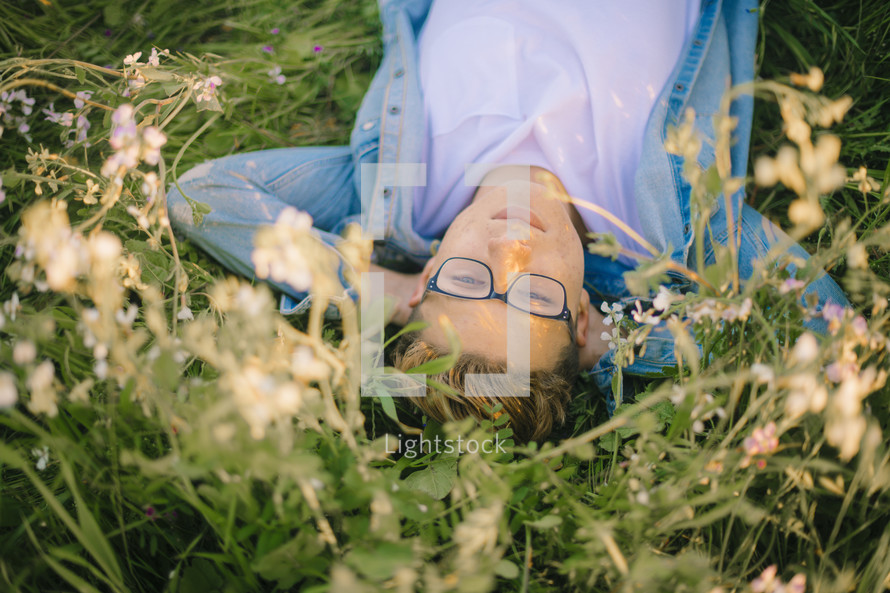 a young man lying in a meadow