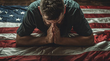 A man lays over a flag and prays