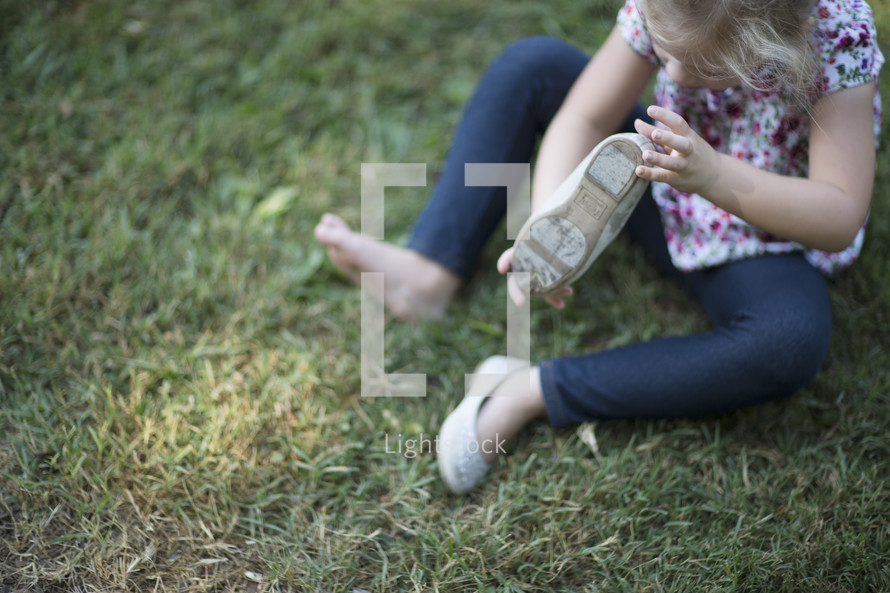 a child putting on her shoes 