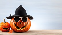 Halloween pumpkin with hat and sunglasses on wooden table. 3d illustration