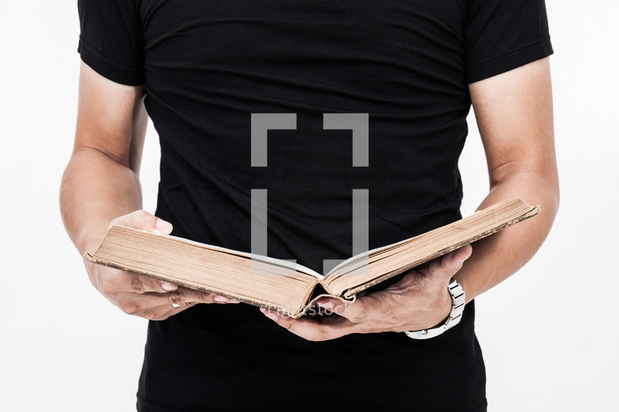 a torso of a man reading a Bible 