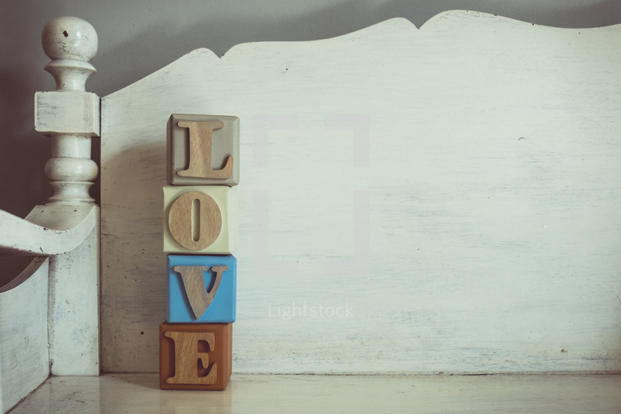 word love in wooden blocks on a white bench 
