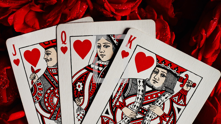 Cards for gambling on roses. Blackjack poker concept. Queen, king, jack of hearts on red roses background. High quality photo