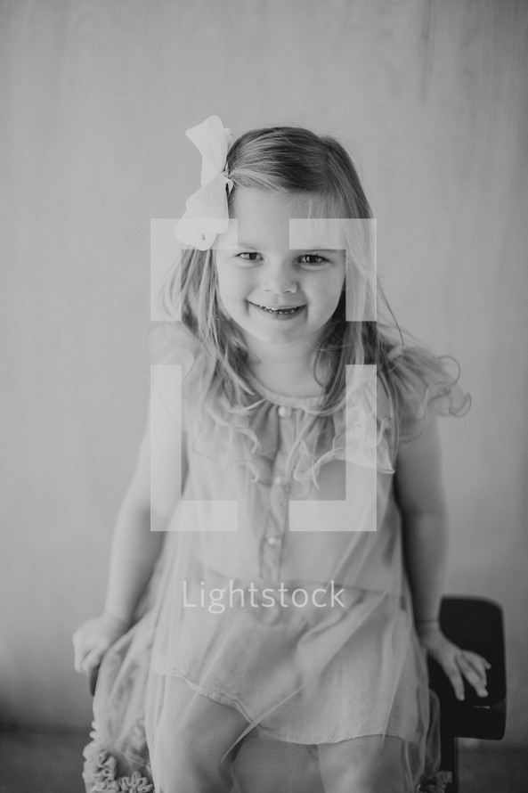 little girl sitting on a stool 