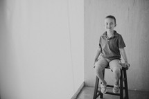 boy child sitting on a stool 