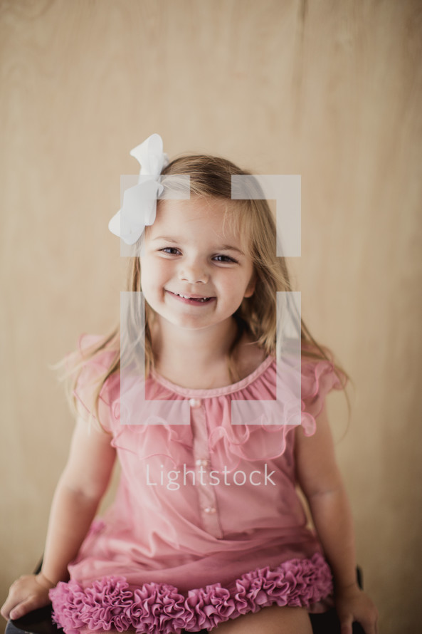 smiling girl child sitting on a stool 