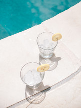 ice in glasses by a poolside 