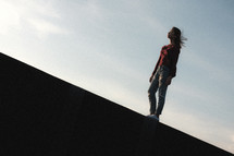 woman walking on the edge of a concrete wall 
