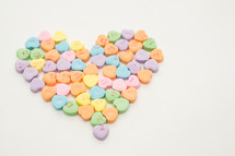 Candy hearts forming a heart shape.