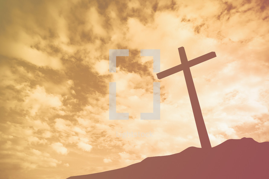 a silhouette of a cross on a mount at sunrise