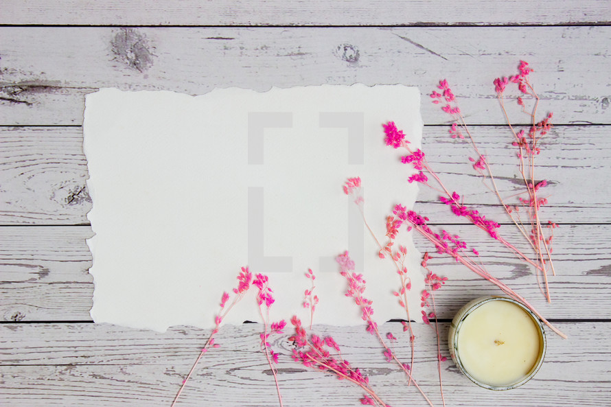 blank paper and pink flowers with candle 