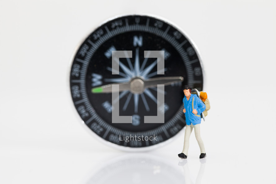 figurine in front of a compass 
