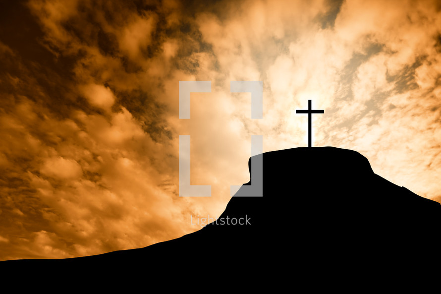 silhouette of a cross on a mount at sunrise 