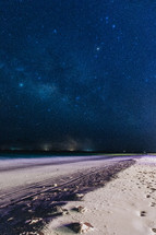 stars over a white sand beach 