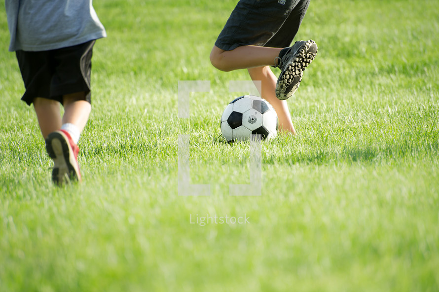 legs of young boys playing soccer