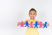 Girl holding a strand of paper dolls.