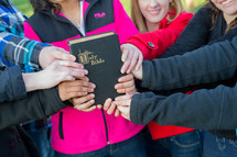 youth group members holding onto a Bible