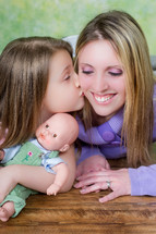 child kissing mother on the cheek