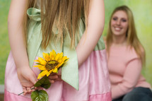 daughter giving mother flowers