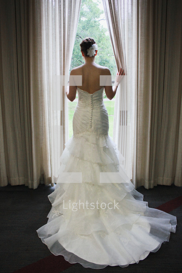bride standing in a window 